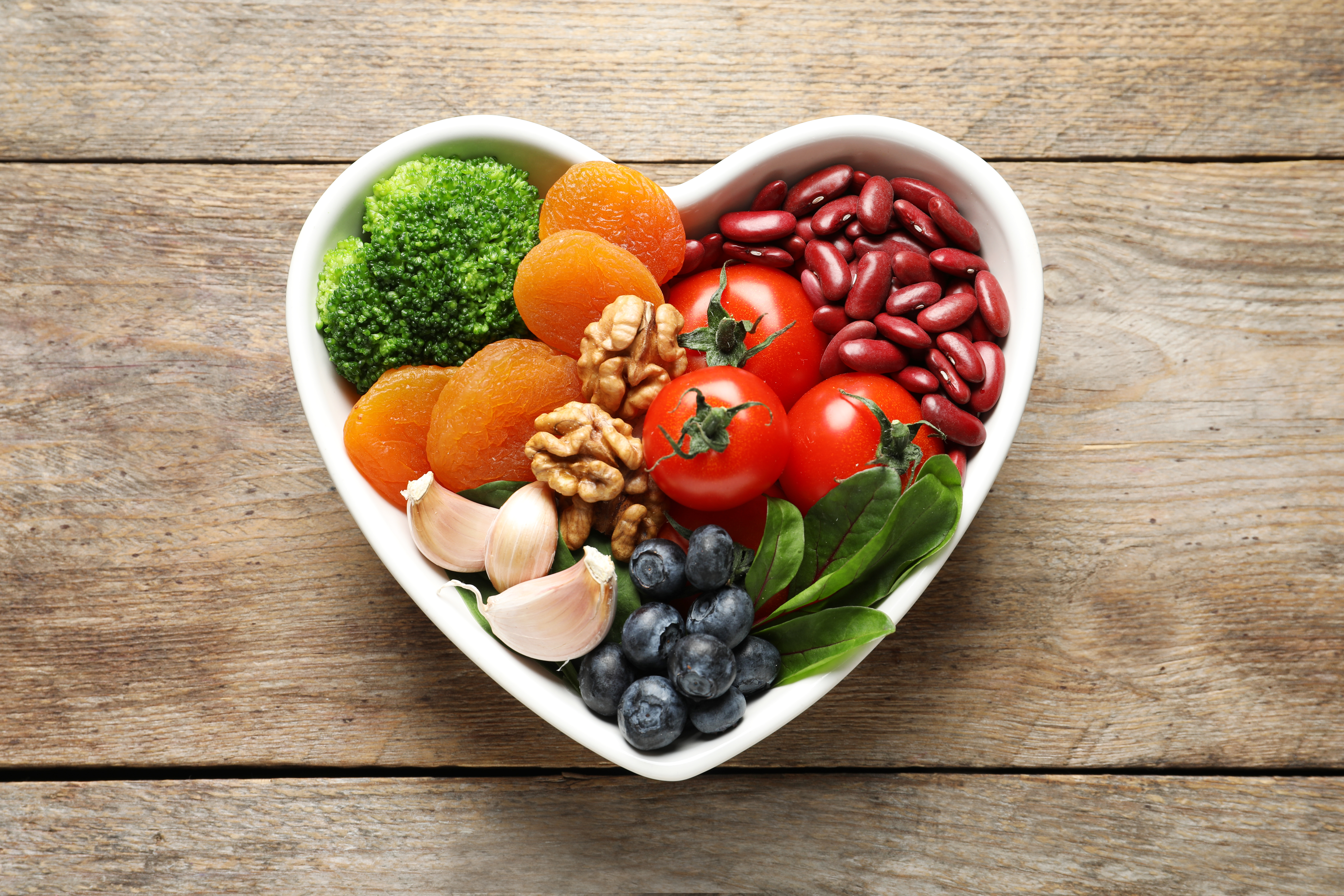 Heart-shaped bowl full of different fruits and vegtables